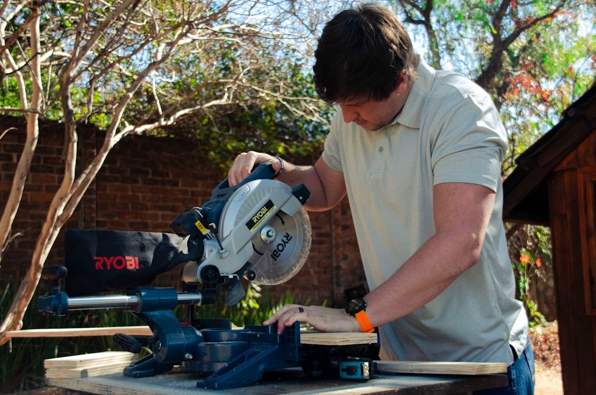 a man using a circular saw to cut a piece of wood
