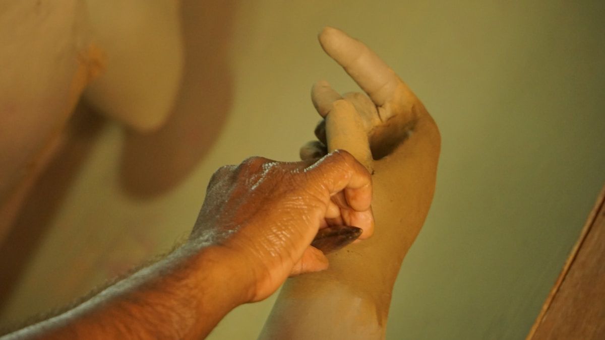 Mains calleuses d'un travailleur effectuant un geste.