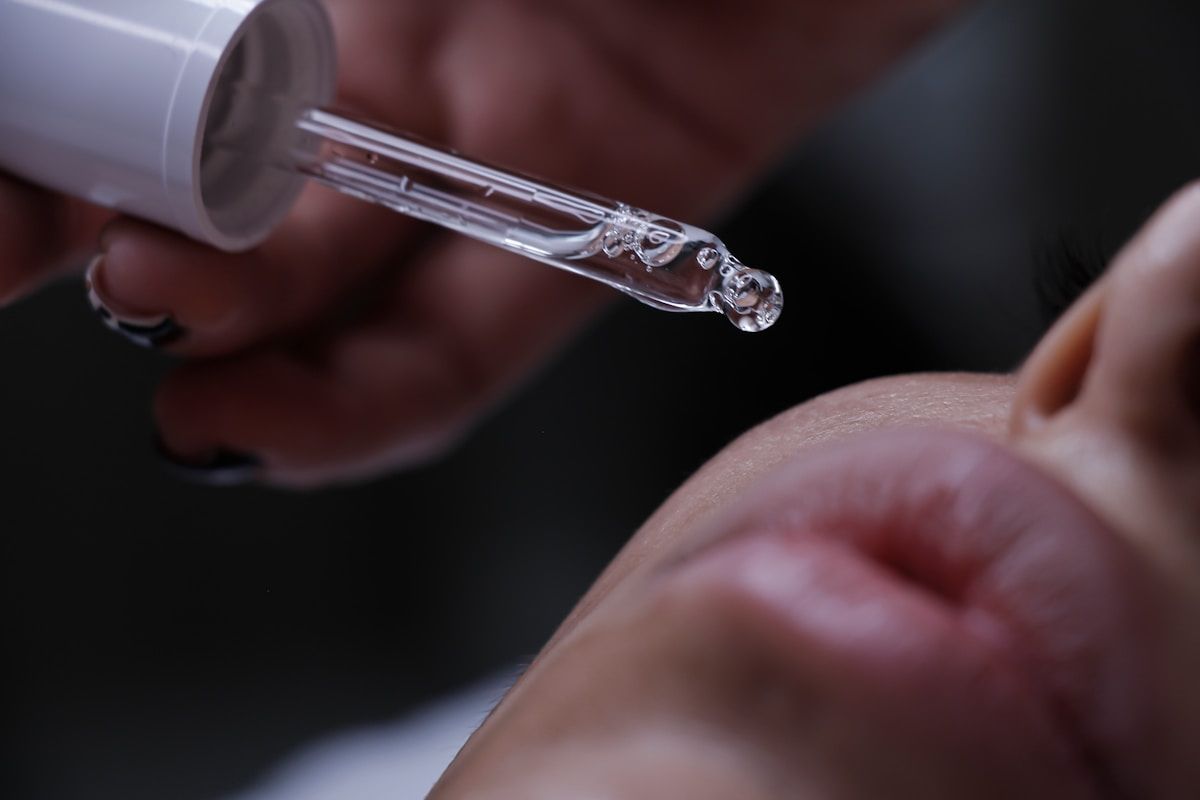 Pipette délivrant un liquide transparent sur une peau.