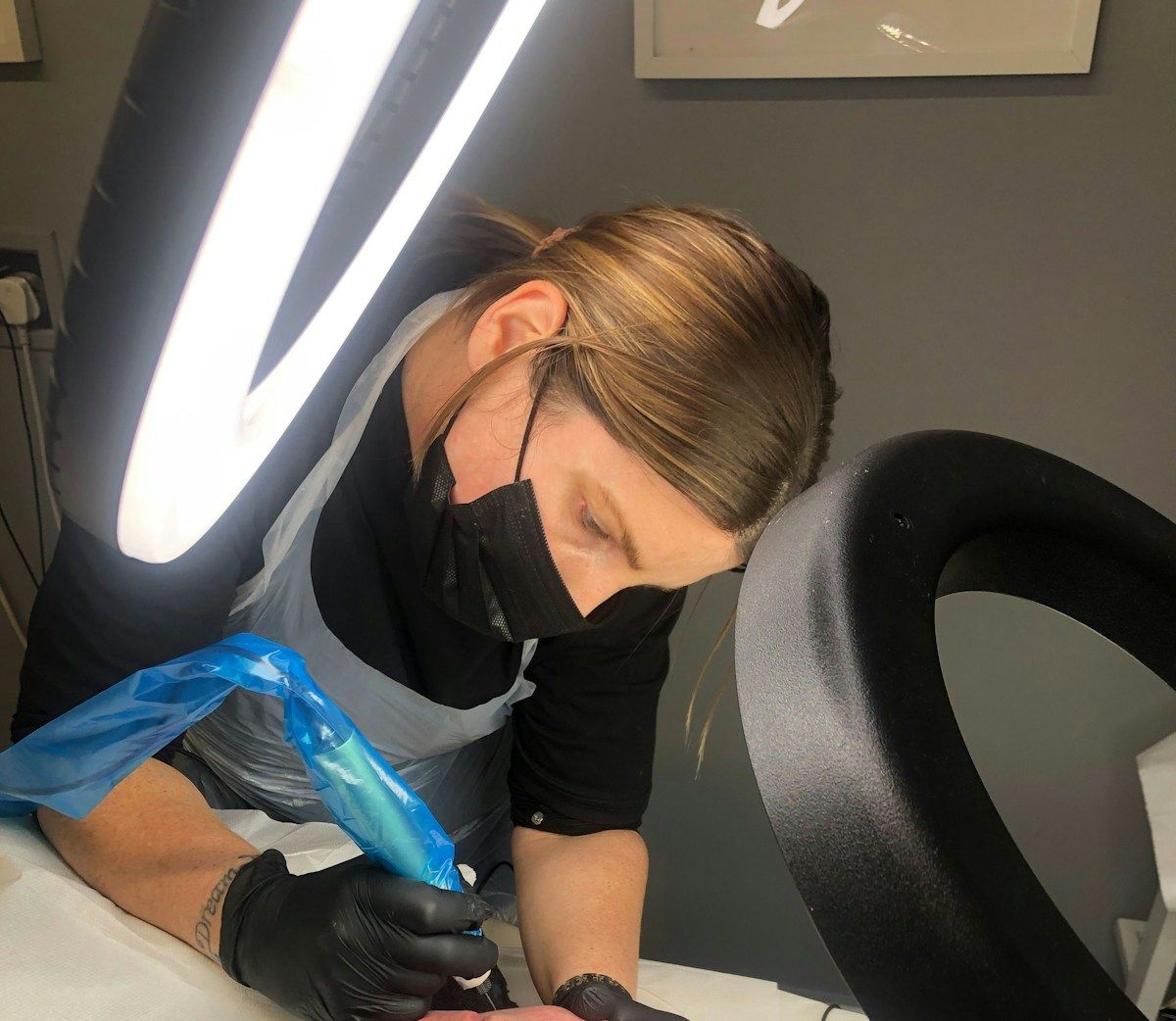 Personne portant un masque médical effectuant un soin médical.