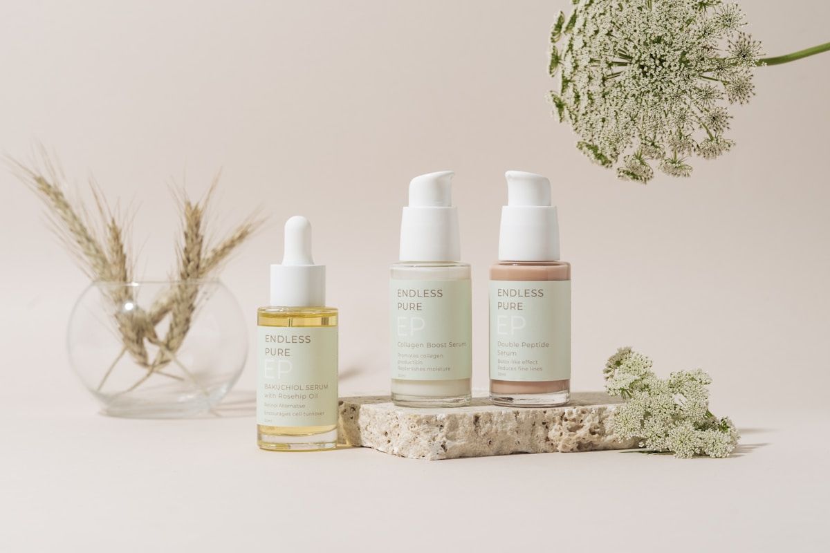 Produits cosmétiques naturels sur un support en pierre avec fleurs sauvages.