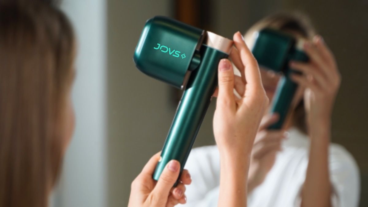 Femme utilisant un sèche-cheveux vert de la marque Jovs.