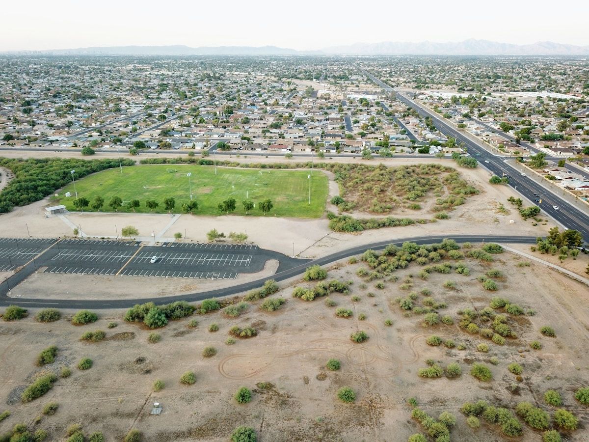 Vue aérienne d'une ville avec un terrain de sport et un parking.