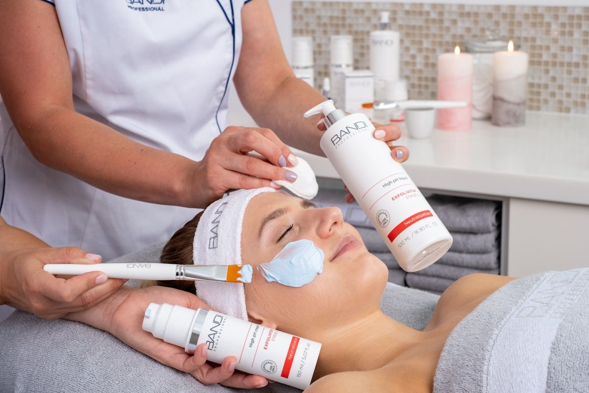 Esthéticienne appliquant un traitement cosmétique sur le visage d'une cliente dans un salon de beauté.
