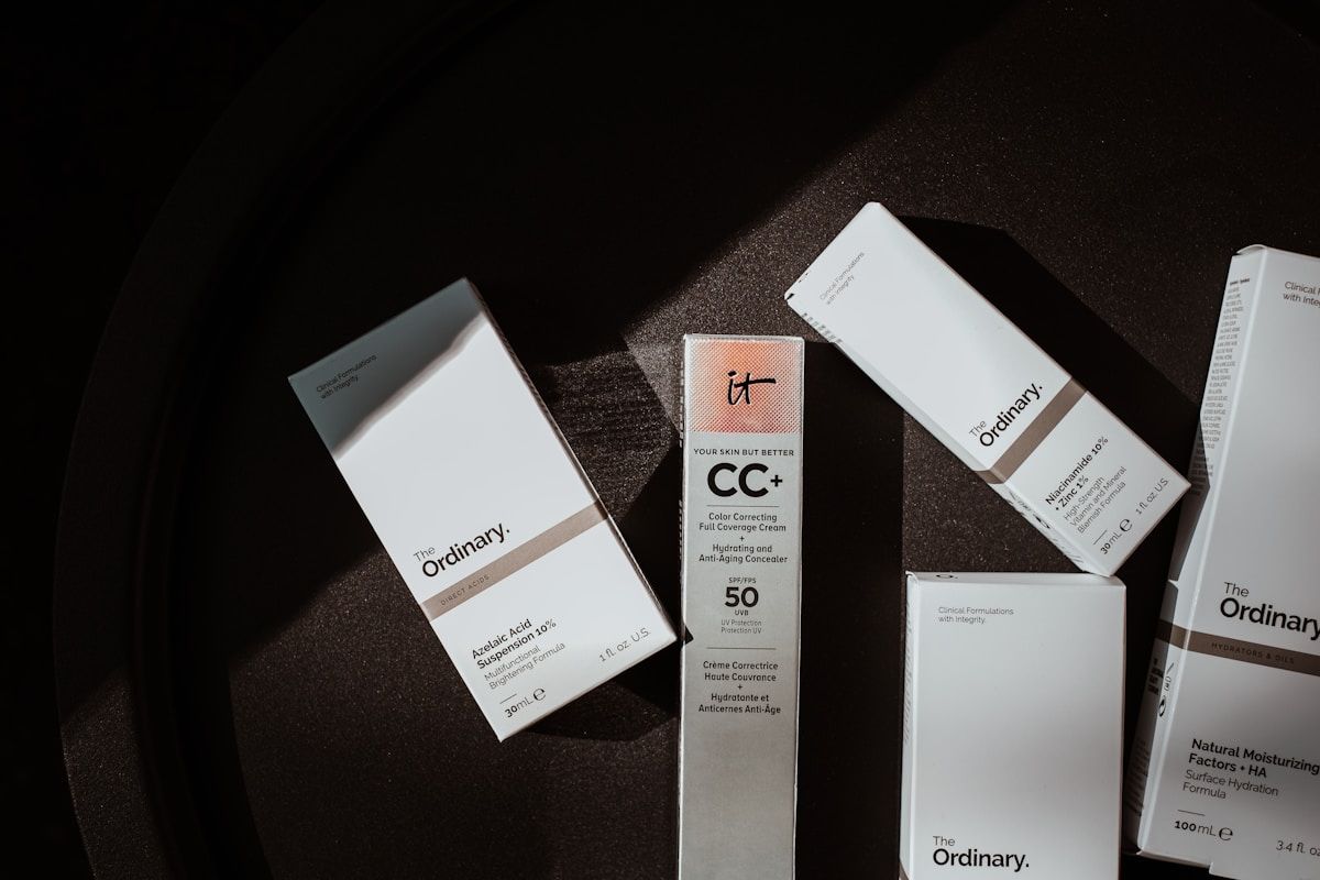 Produits cosmétiques de la marque The Ordinary sur fond sombre.