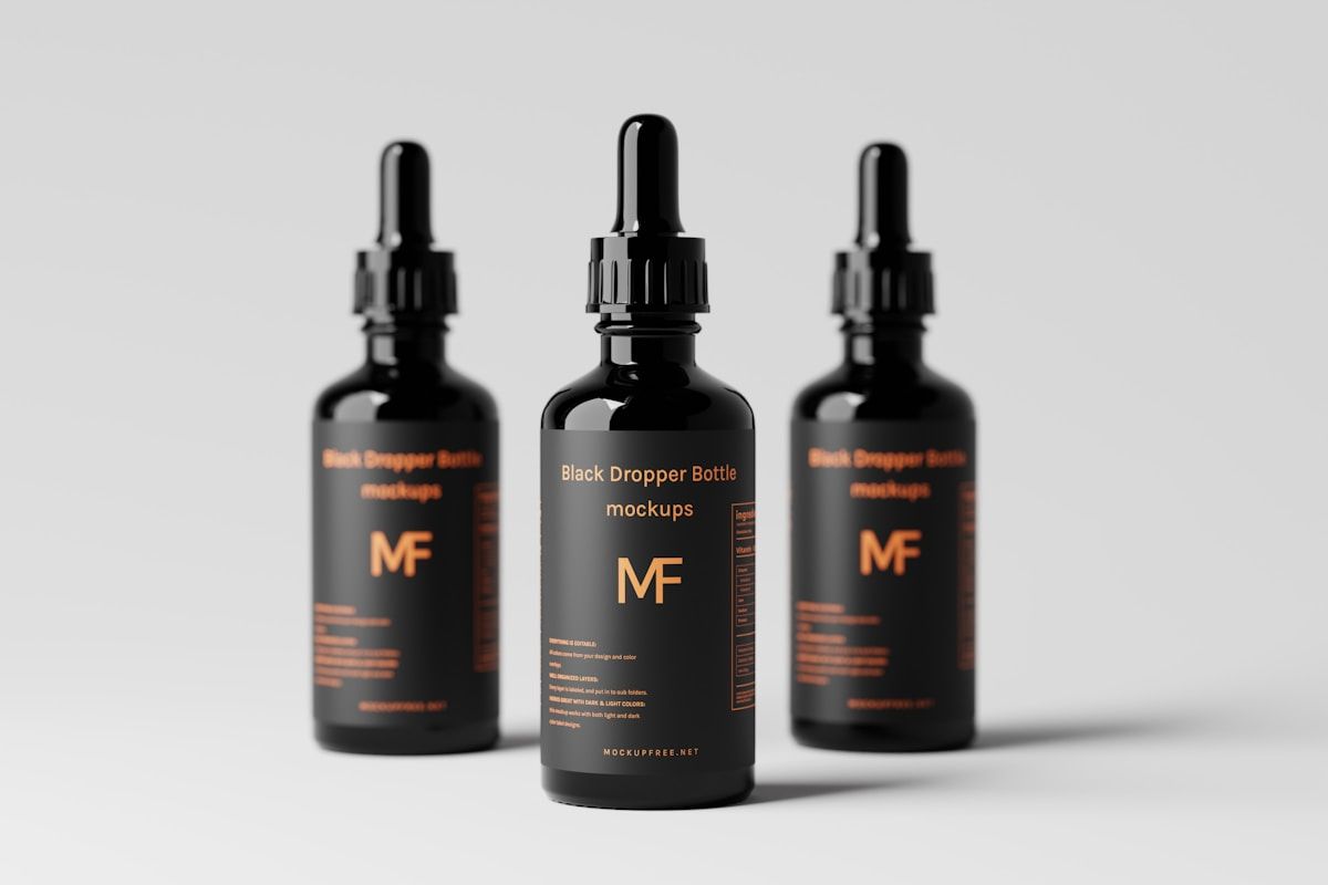 Bouteilles noires avec compte-gouttes, étiquette MF, fond gris.