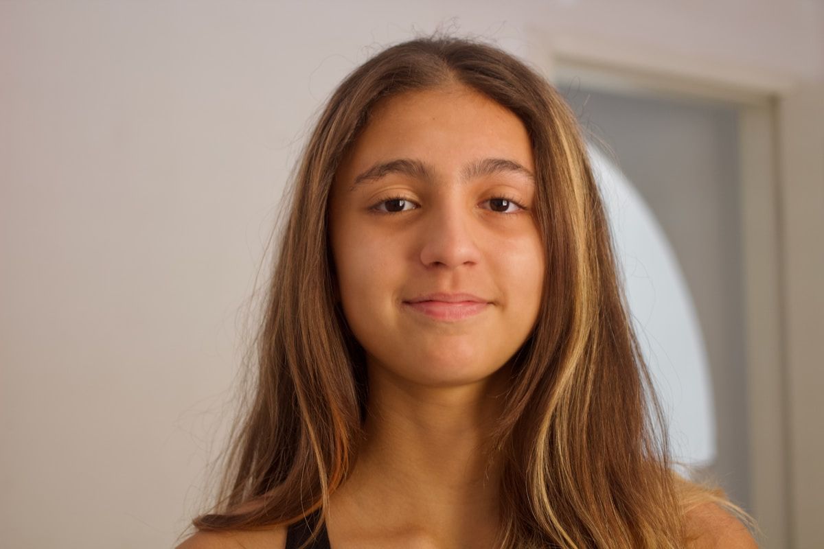 Jeune femme aux cheveux bruns et au regard direct.