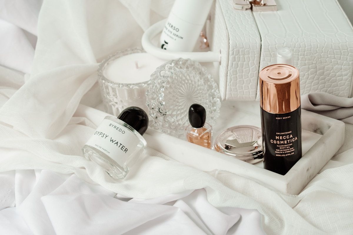 Produits cosmétiques de luxe sur un lit blanc et moelleux.