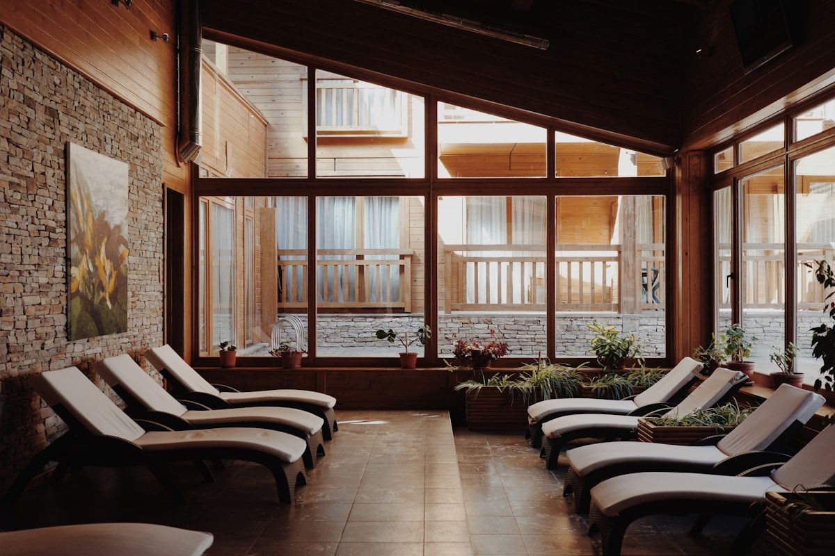Salle de détente confortable avec meubles de relaxation et grandes fenêtres.