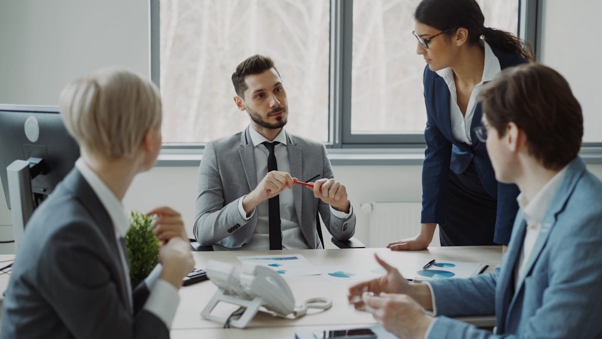 Réunion d'affaires avec des professionnels discutant de documents sur la table.