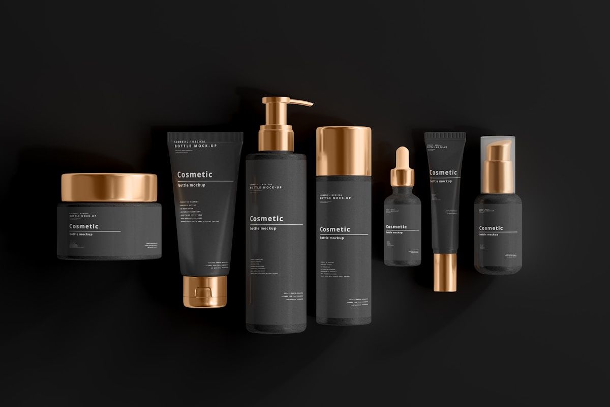 Produits cosmétiques noirs et dorés sur fond noir.