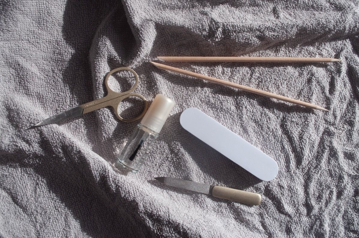 Outils de manucure sur une serviette grise.