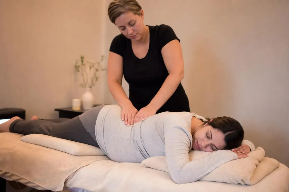 Femme enceinte recevant un massage abdominal relaxant.
