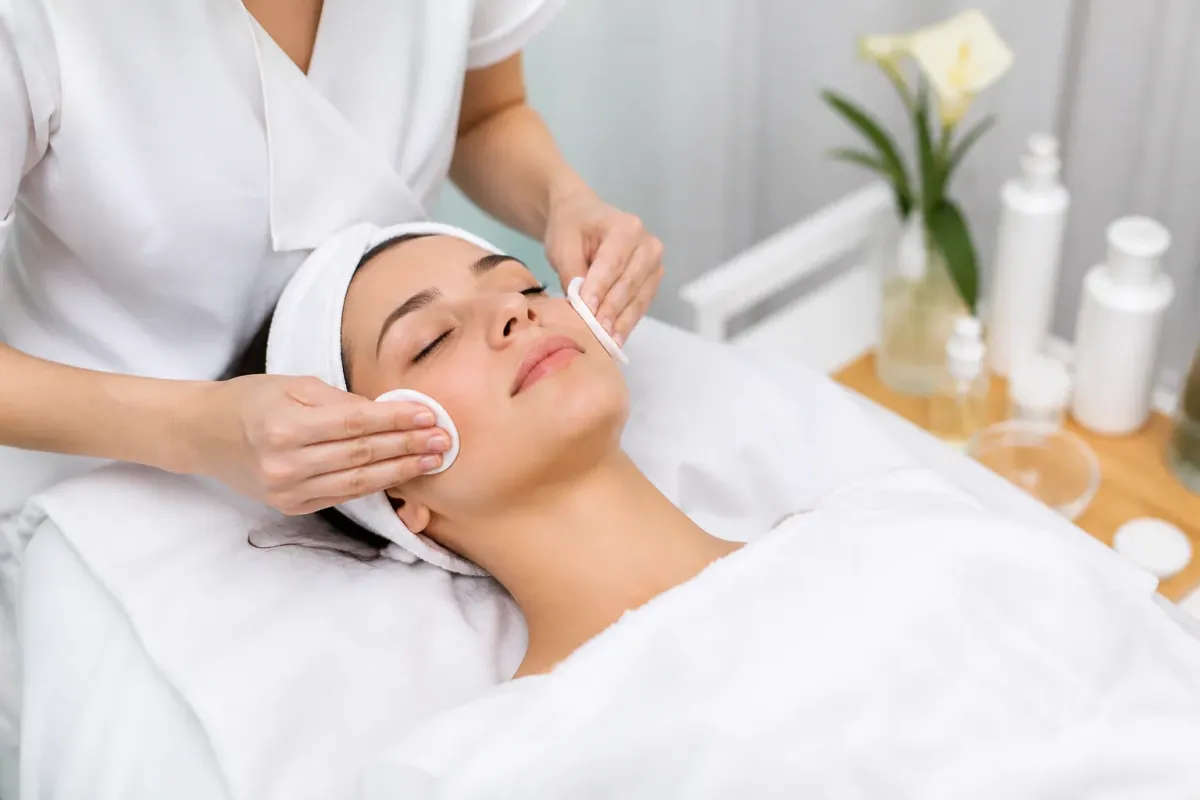 Femme recevant un soin facial dans un salon de beauté.