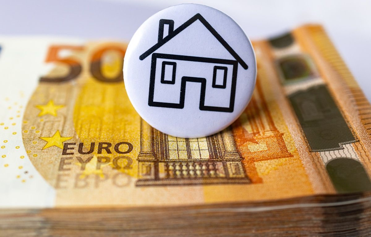 Maison en bouton sur billet de banque en euros.