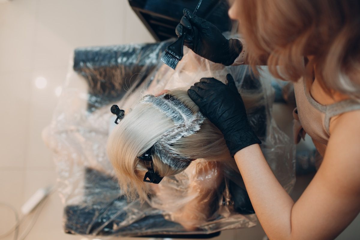Coiffure de femme blonde en cours de coloration des cheveux.
