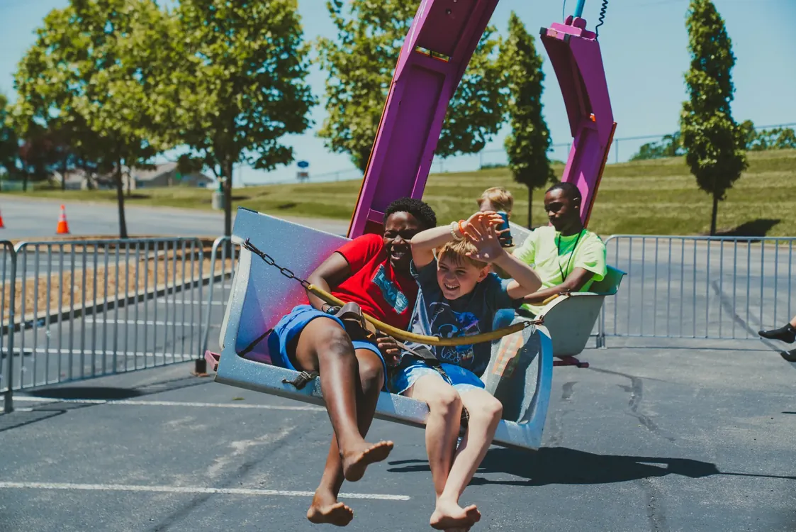 Kids laughing on a swing ride at Party in the Park