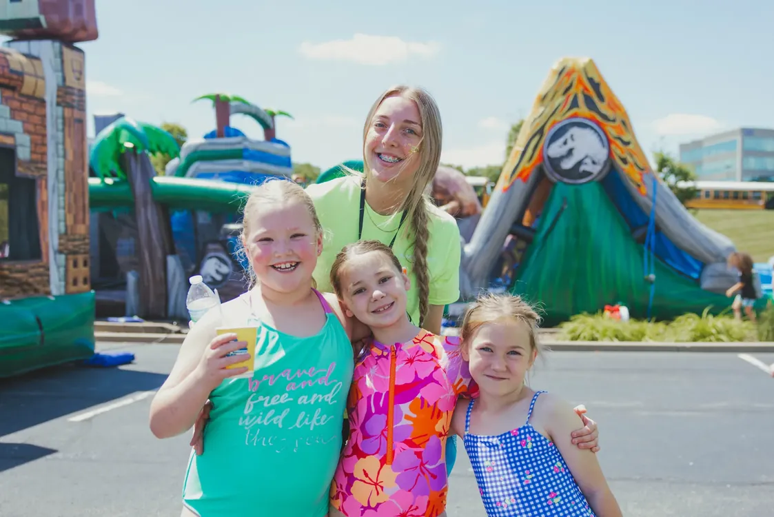 Leader with three girls in front of inflatables