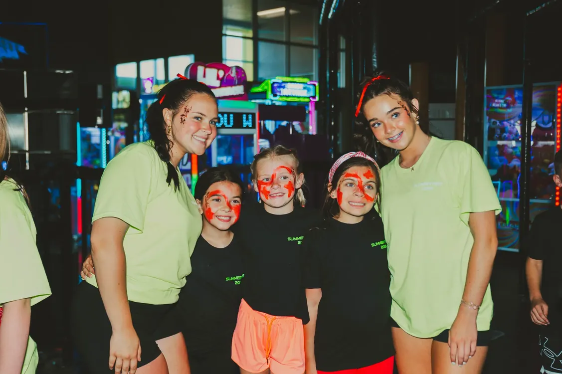 Leaders and girls with face paint posing together