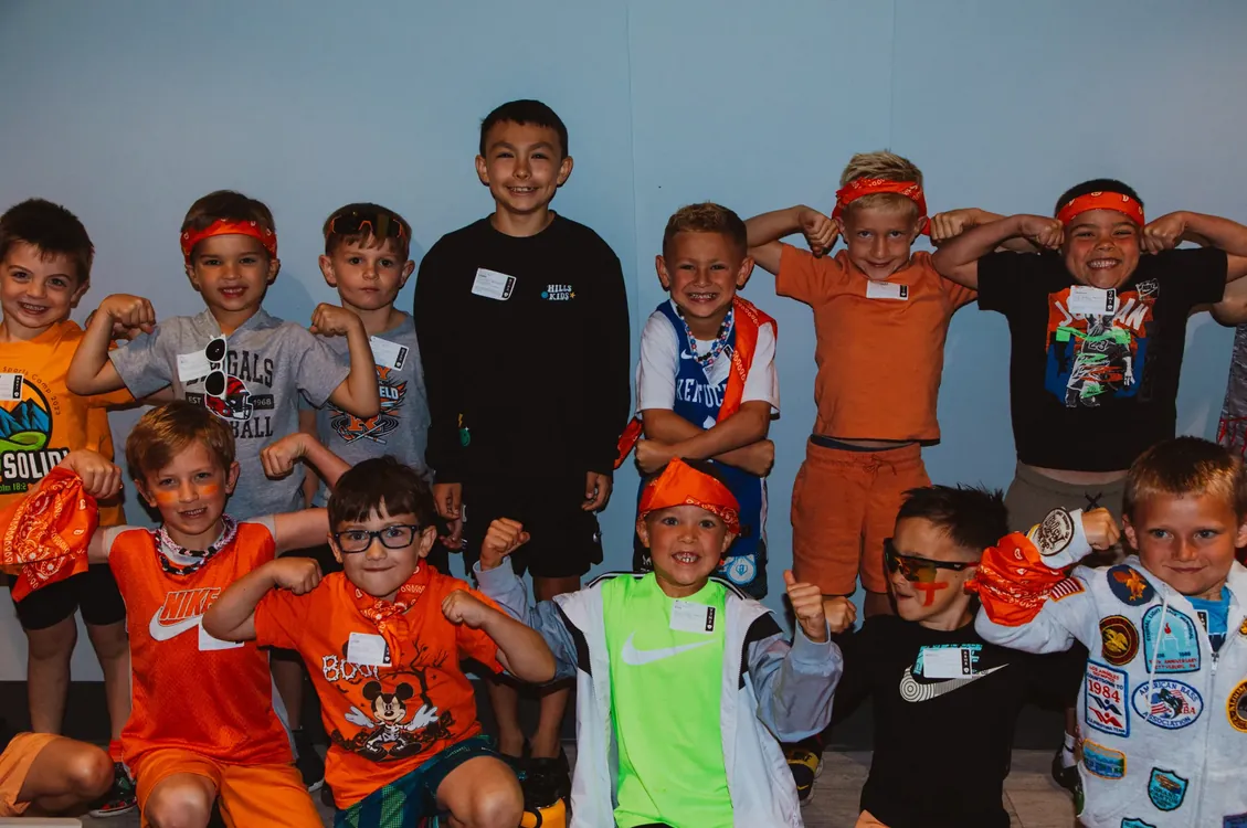 Boys in orange bandanas flexing for the camera