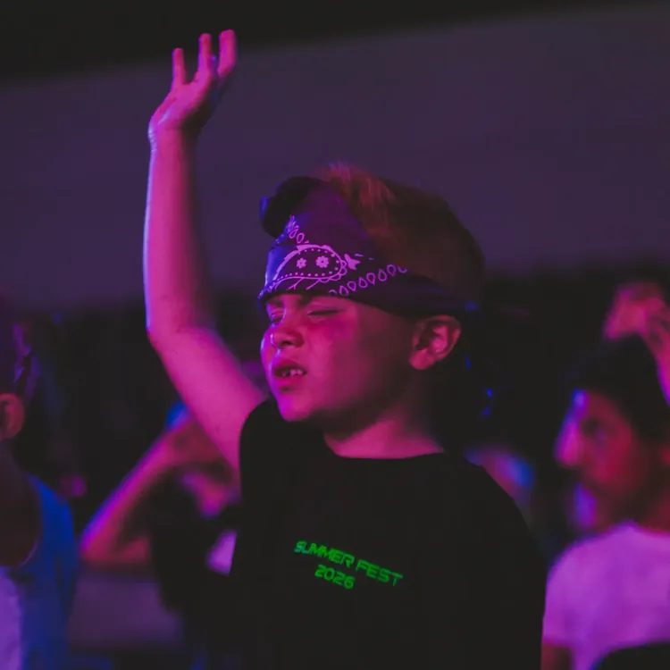 Boy raising his hand during worship