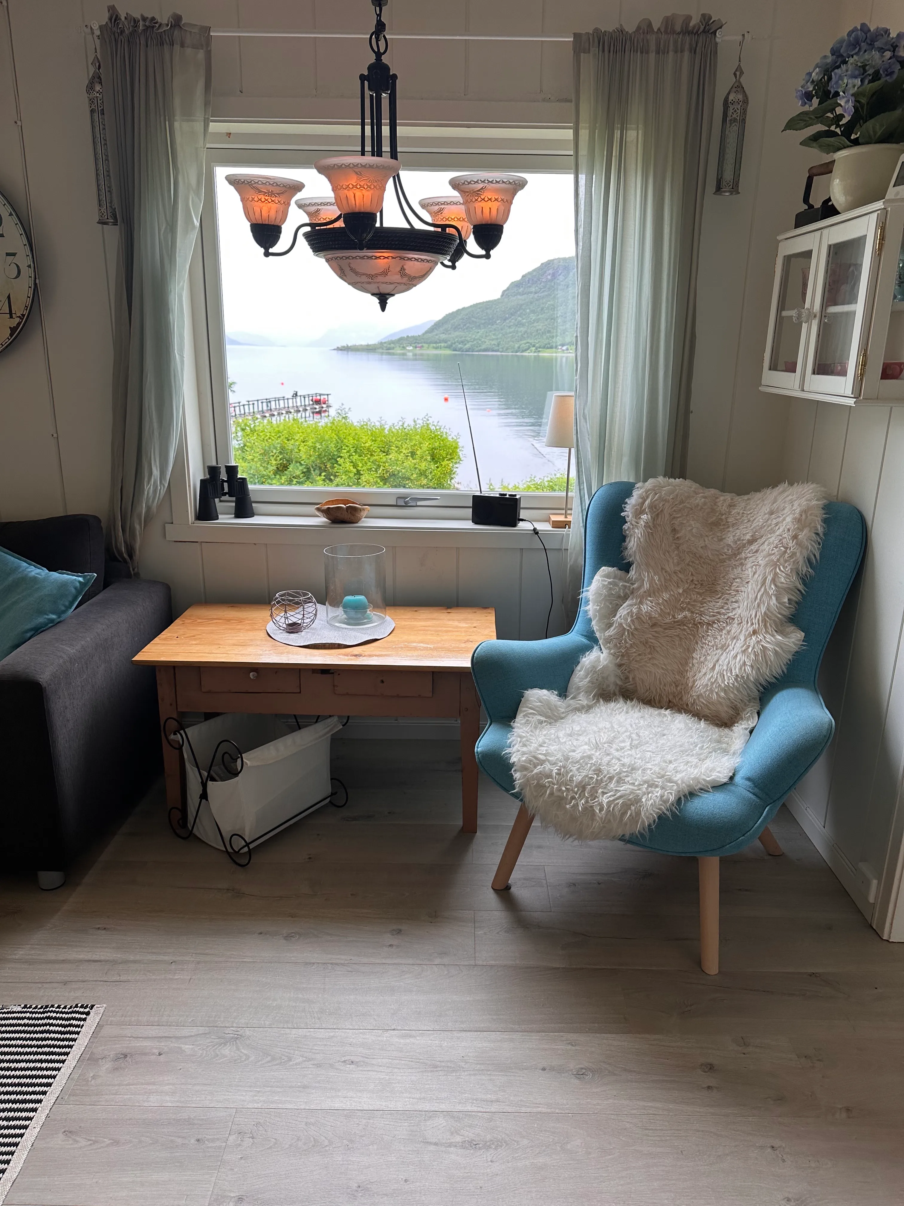 Cozy indoor seating corner with a comfortable armchair, side table, and window view.