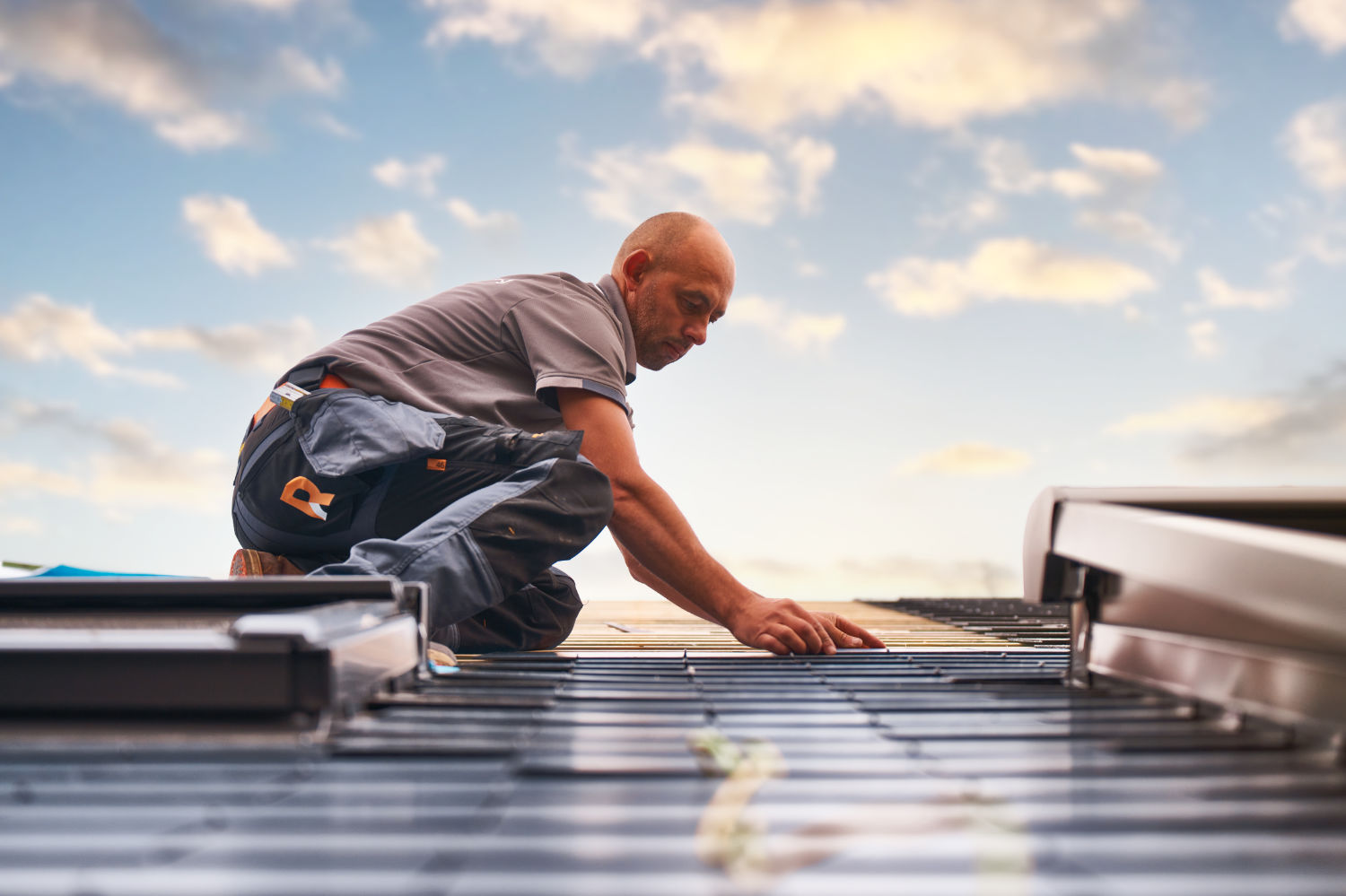 Dakwerker van Roozenburg Dakwerken aan het werk op een dak met leien en dakraam van Velux