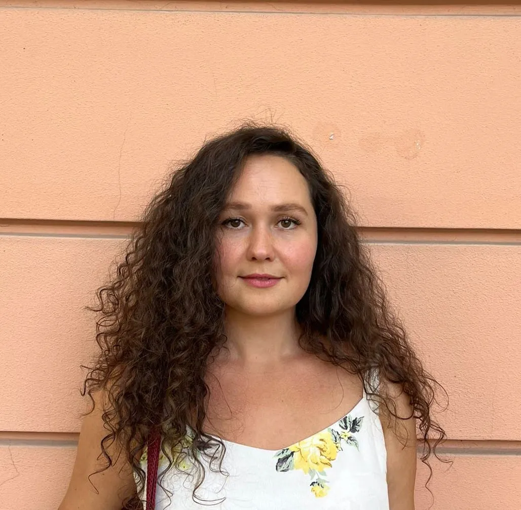 Enseignante d'anglais avec cheveux longs bruns et frisés