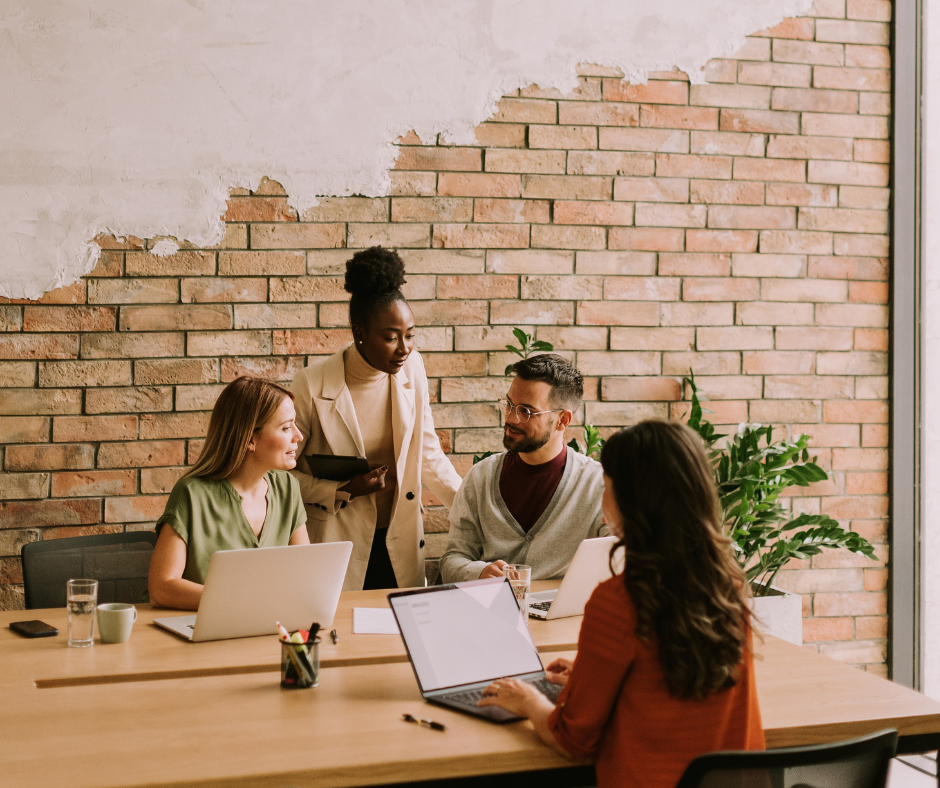Bild von vier Personen, die gemeinsam an einem Tisch sitzen und sich beraten