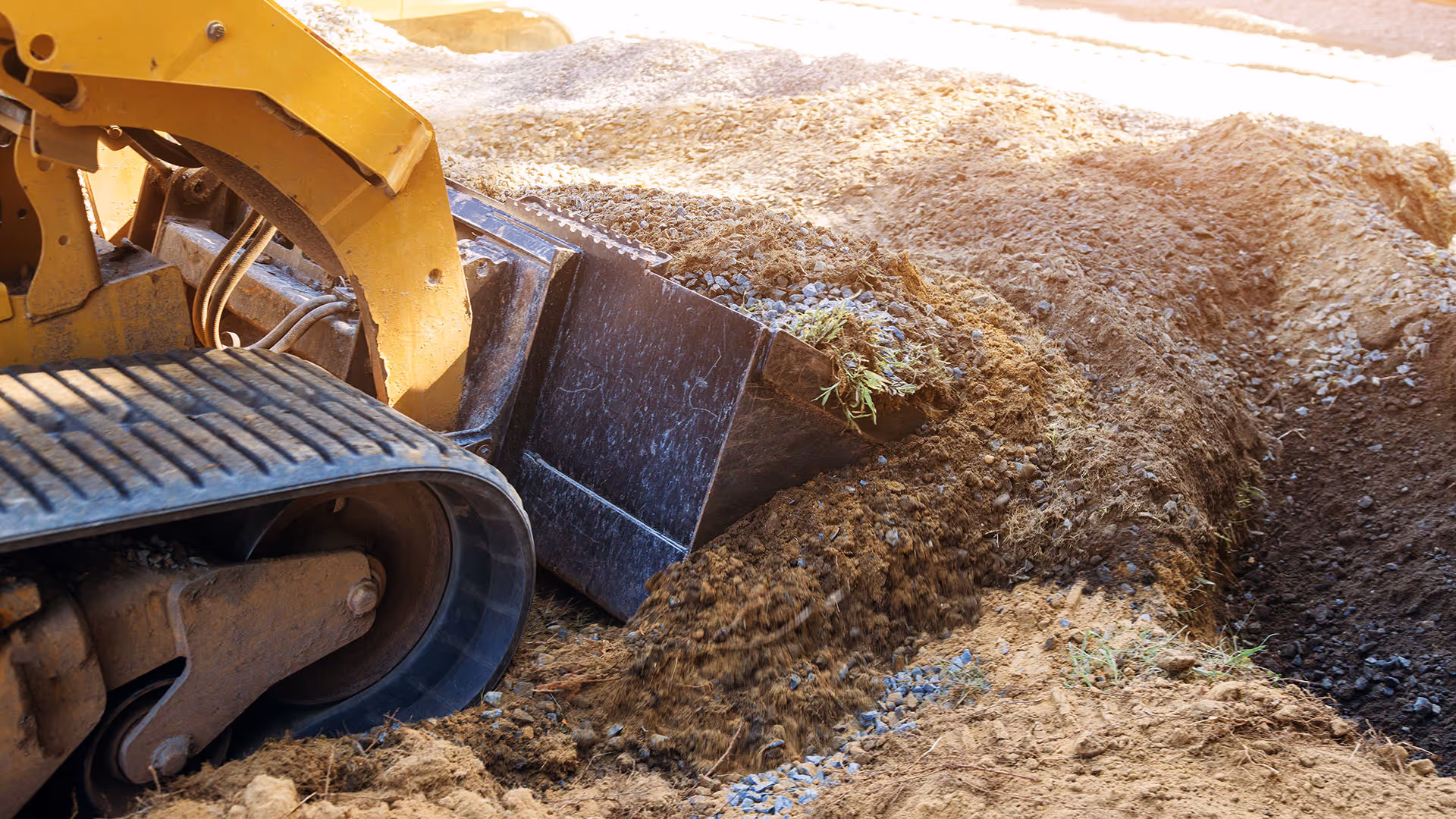 Excavator shifting dirt and soil for new plantings.