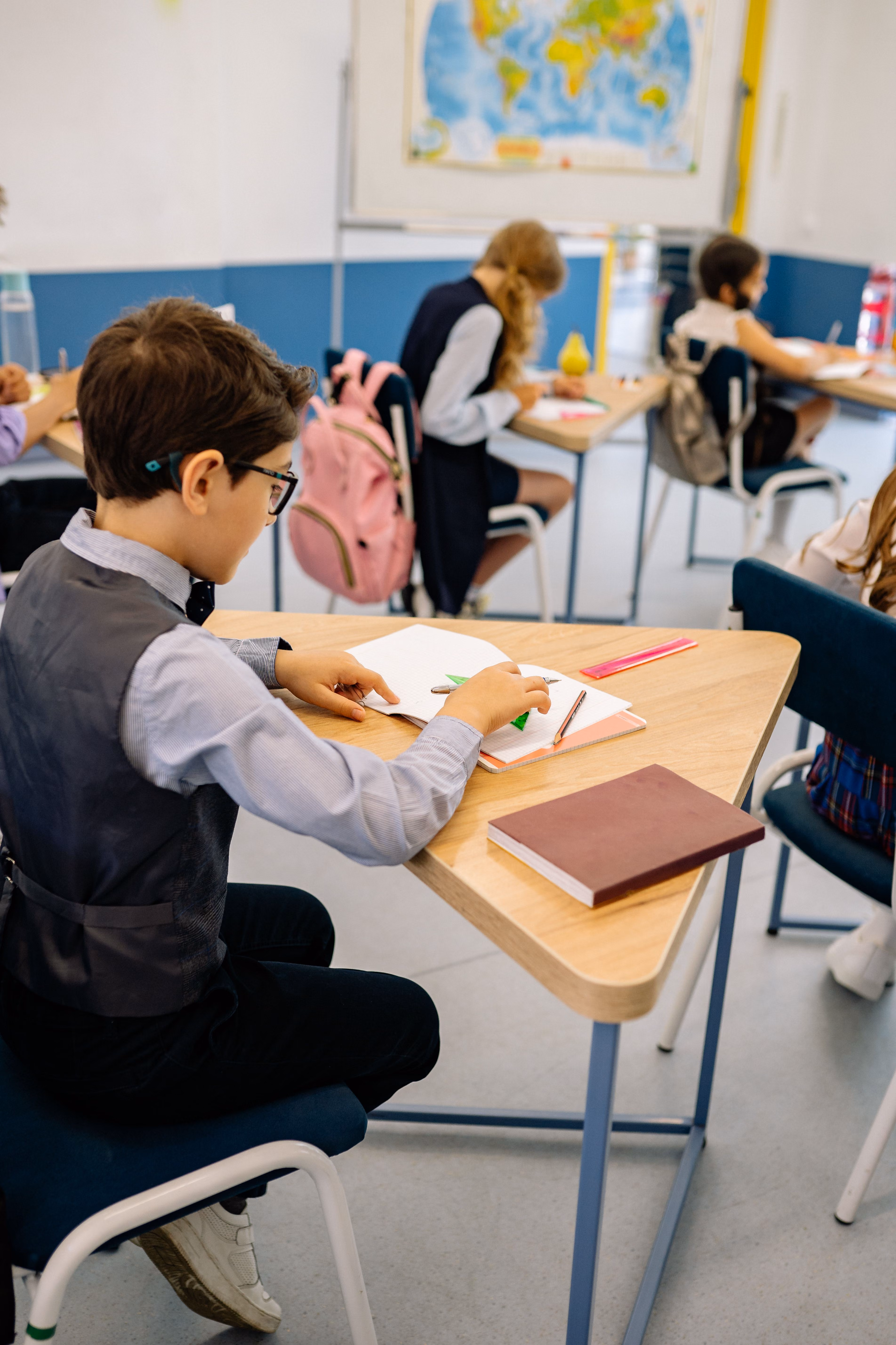 Students working at their desks in a bright classroom