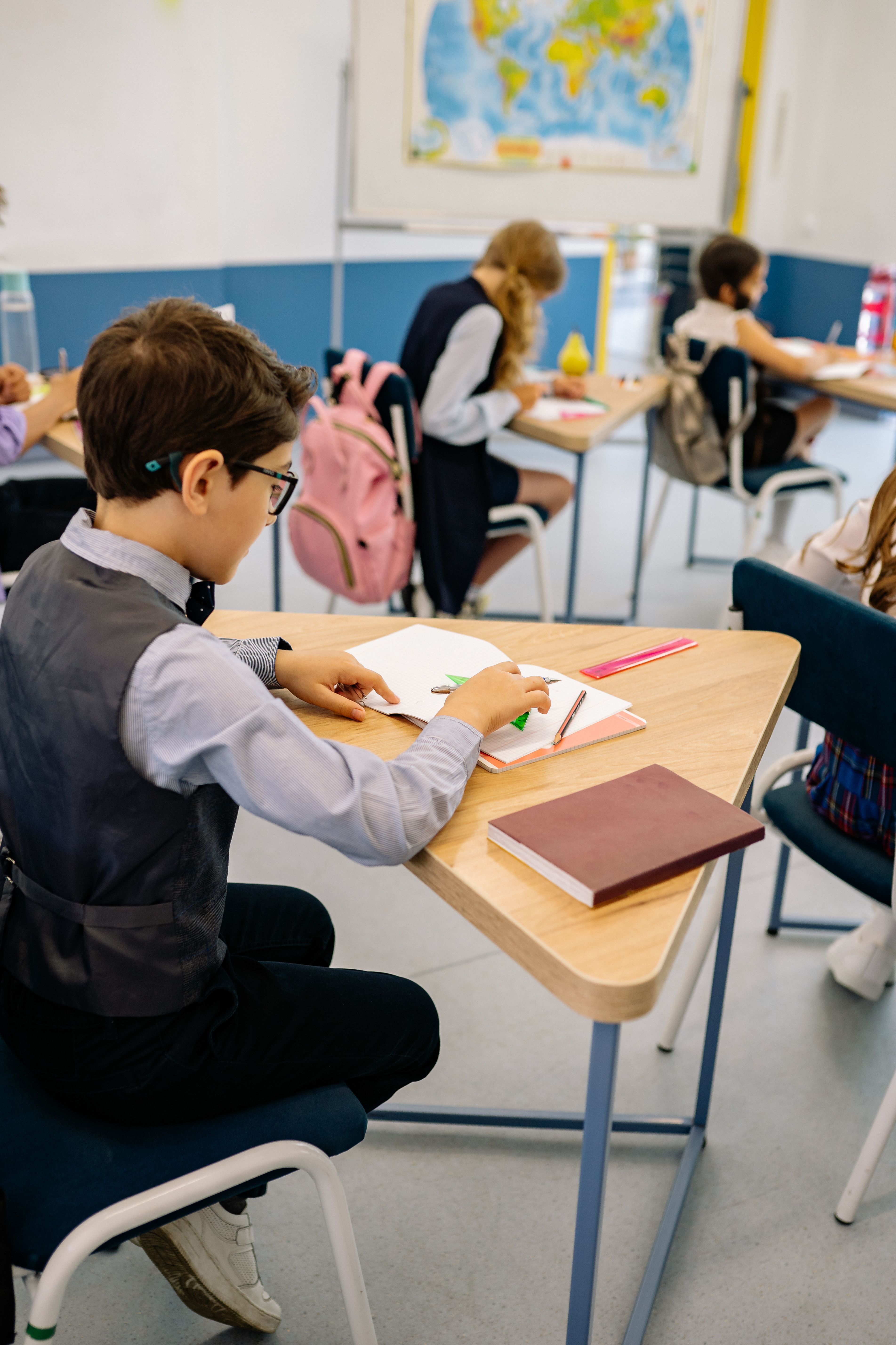 Students working at their desks in a bright classroom