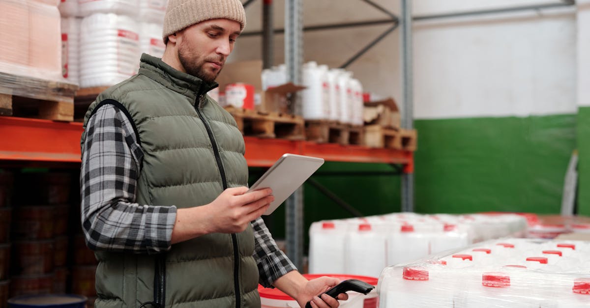 Warehouse manager reviewing inventory data on tablet at industrial fulfillment operation