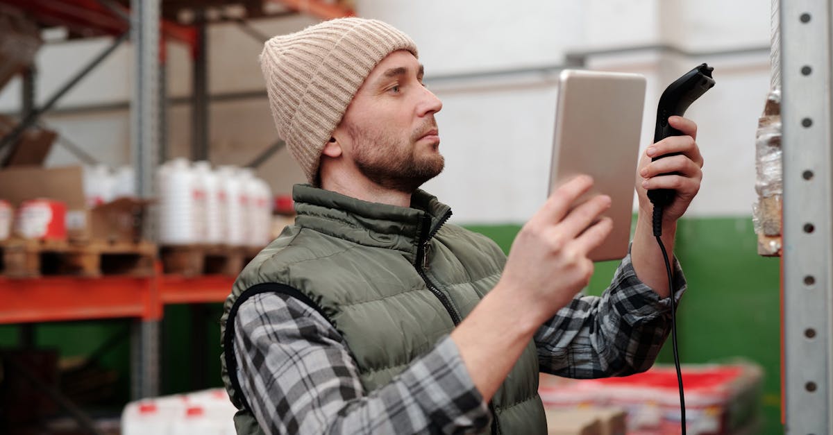 Warehouse worker scanning inventory with handheld scanner in industrial fulfillment center