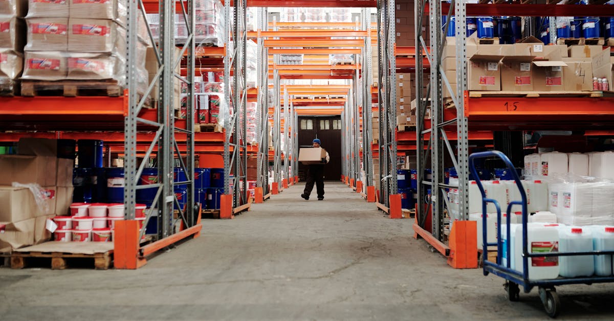 Warehouse worker carrying a box in organized storage for 3PL order fulfillment