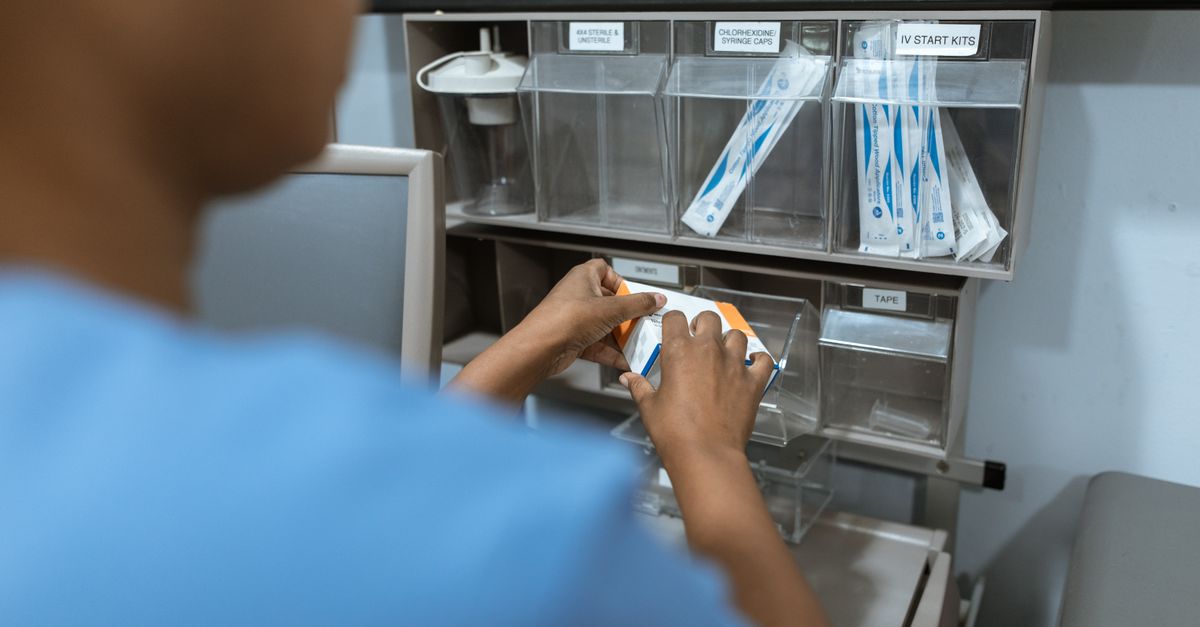Nurse organizing medical supplies on a hospital supply room shelf