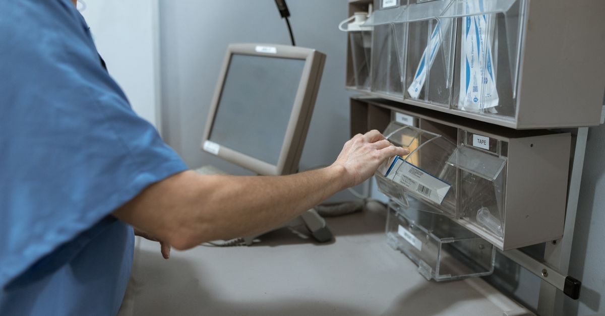 Healthcare worker organizing medical supplies into labeled bins in a storage room