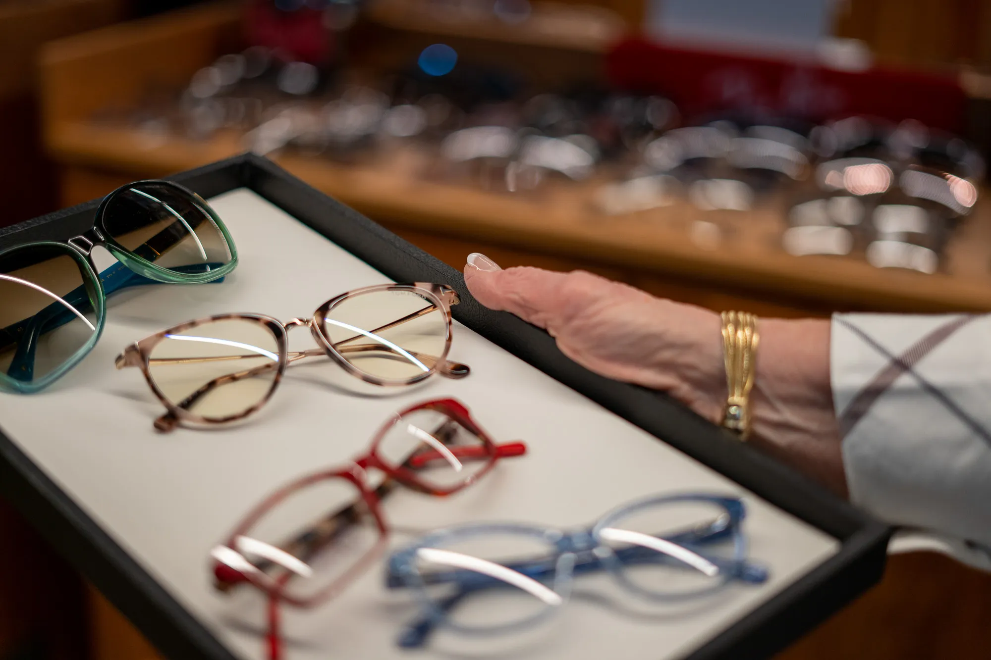 Women looking over four different pairs of glasses