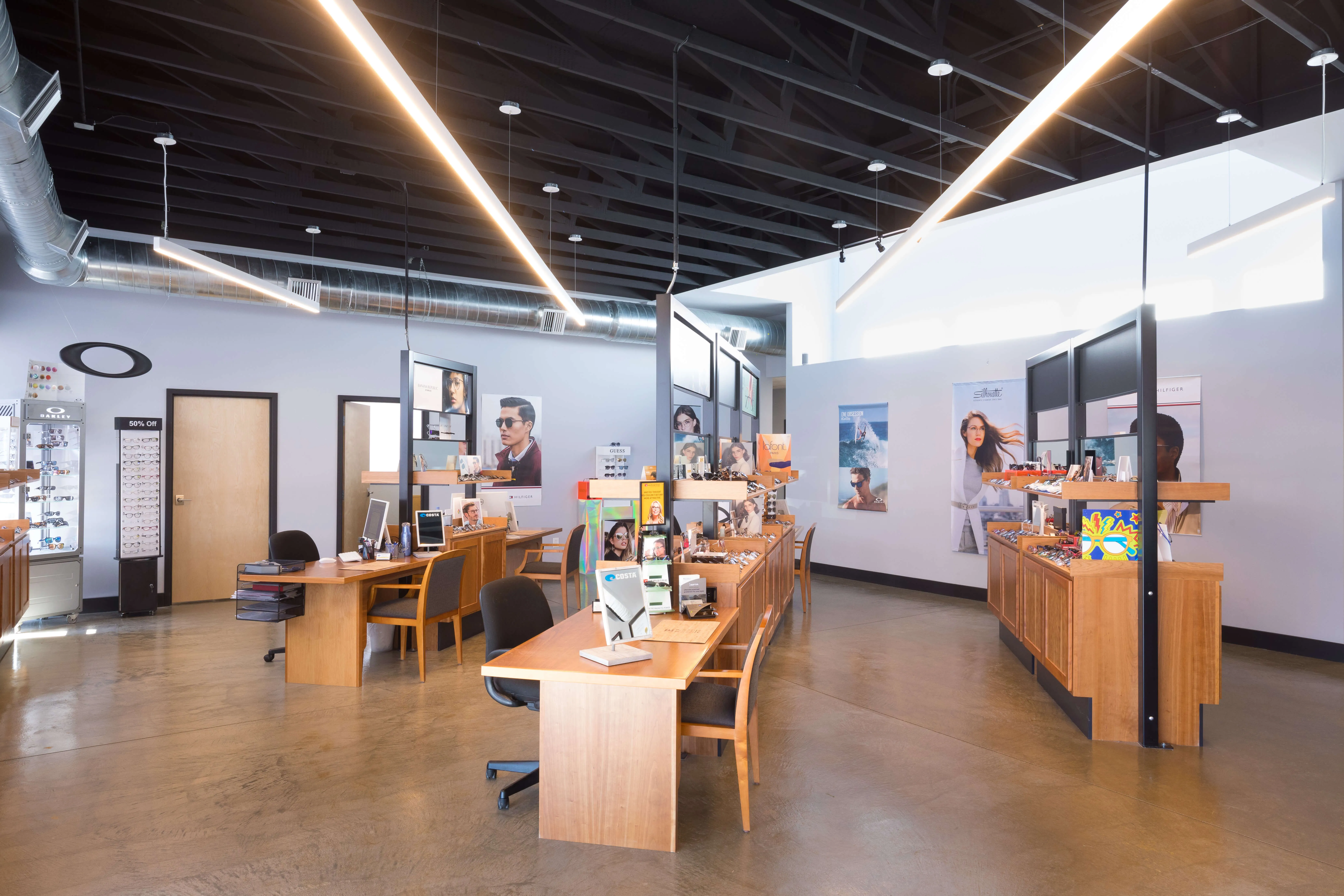 Inside view of Carbon Valley Eye Care with wooden desks and glasses all around