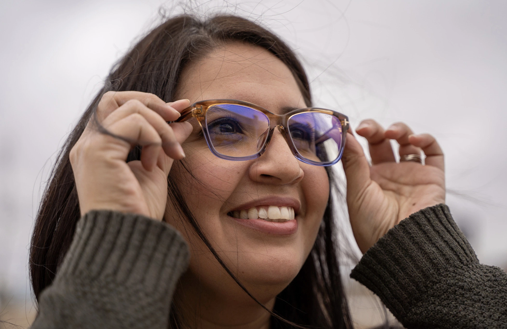 Woman holding the frame of her glasses