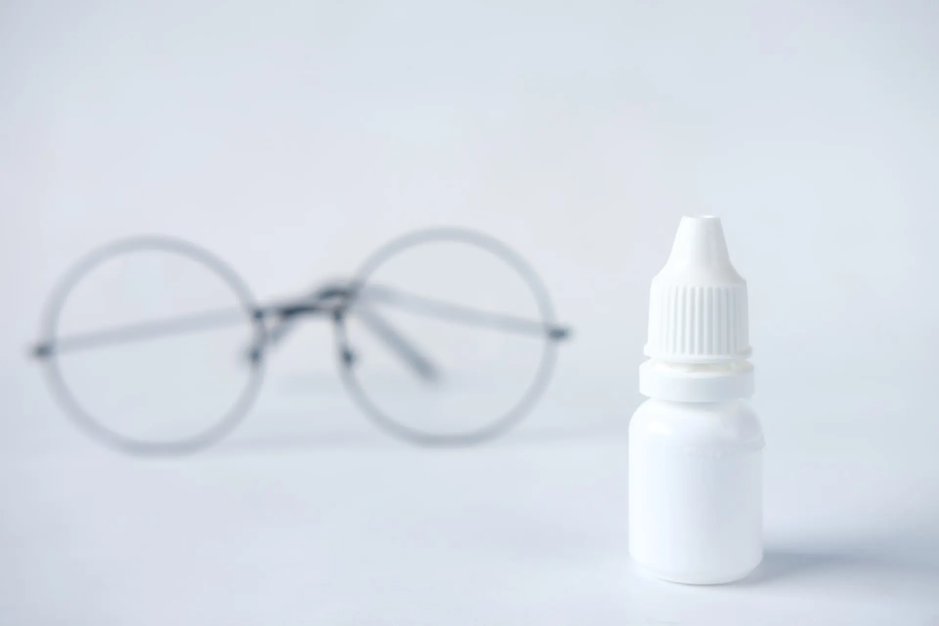 round glasses and eye drops