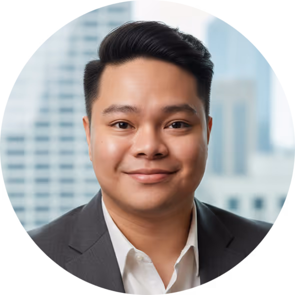 Smiling man with short black hair wearing white shirt and dark blazer with blurred city background.