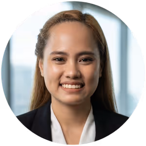 Portrait of a woman with long hair smiling, wearing a black blazer and white shirt.