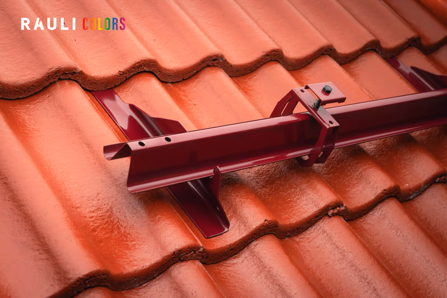 Punainen rauli aurinkopaneeli kiinnike asennettuna punaisen tiilikaton päälle.