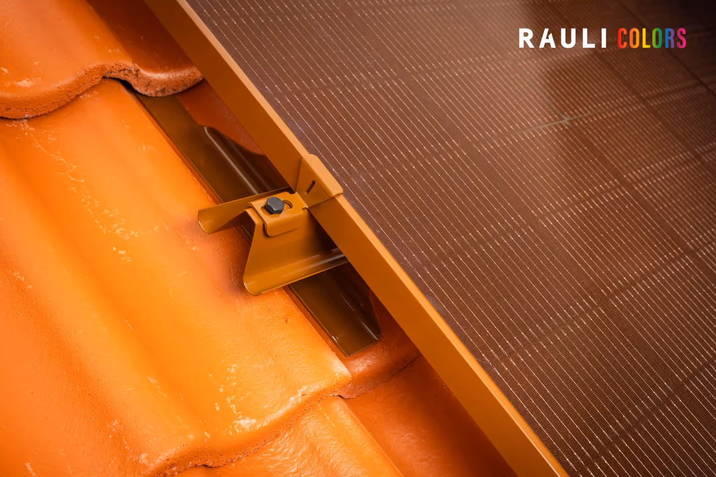 Oranssin kattotiilen päällä oleva terrakotan värinen rauli aurnkopaneeli kiinnike ja oranssi paneeli.