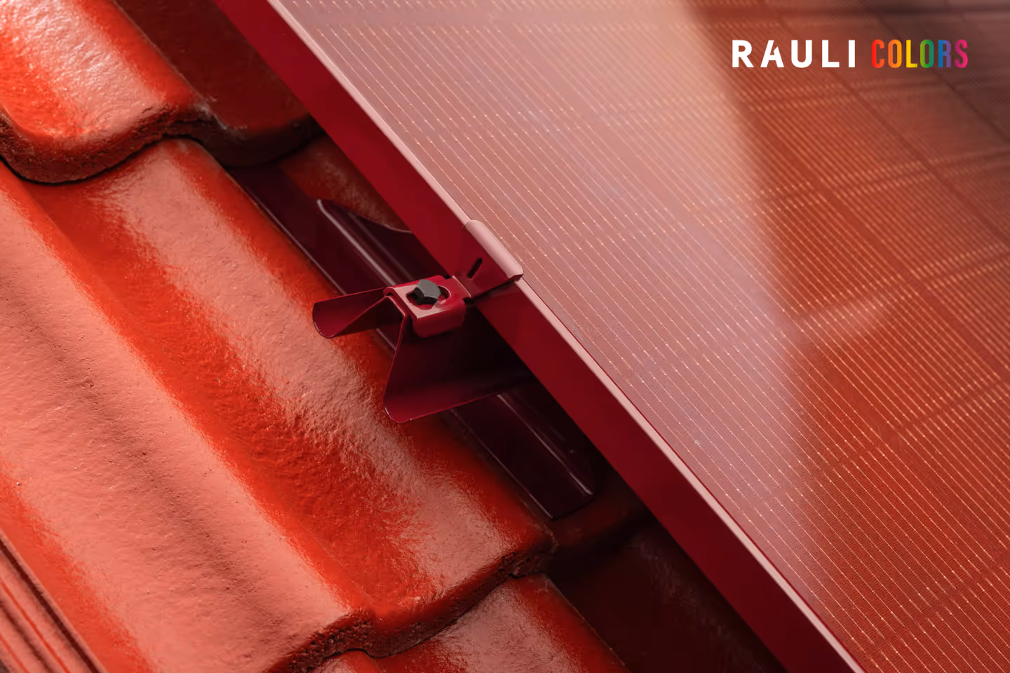 Punainen kattopelti, johon on asennettu aurinkopaneeli punaisella kiinnikkeellä.