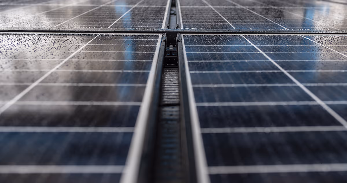 Läheltä kuvattu RAULI WALL, aurinkopaneelit rinnakkain metallikehyksissä.