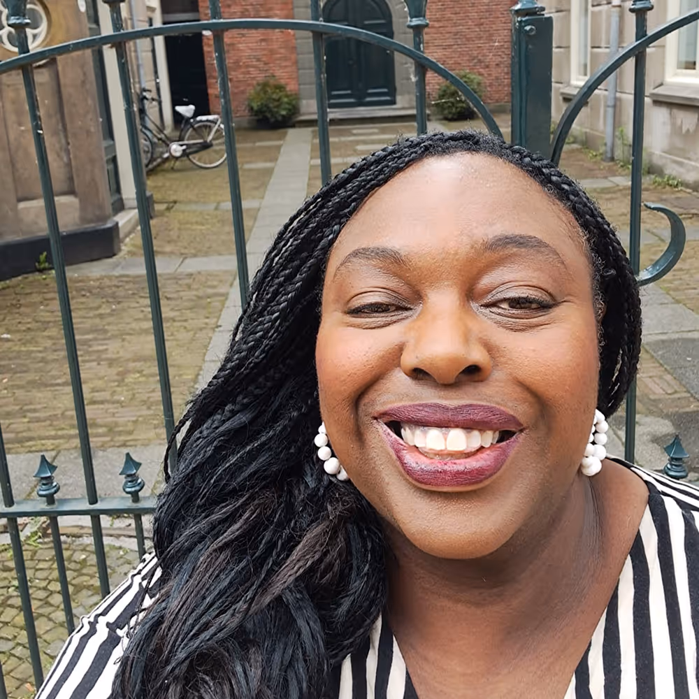 Een foto van Ketura voor een hek