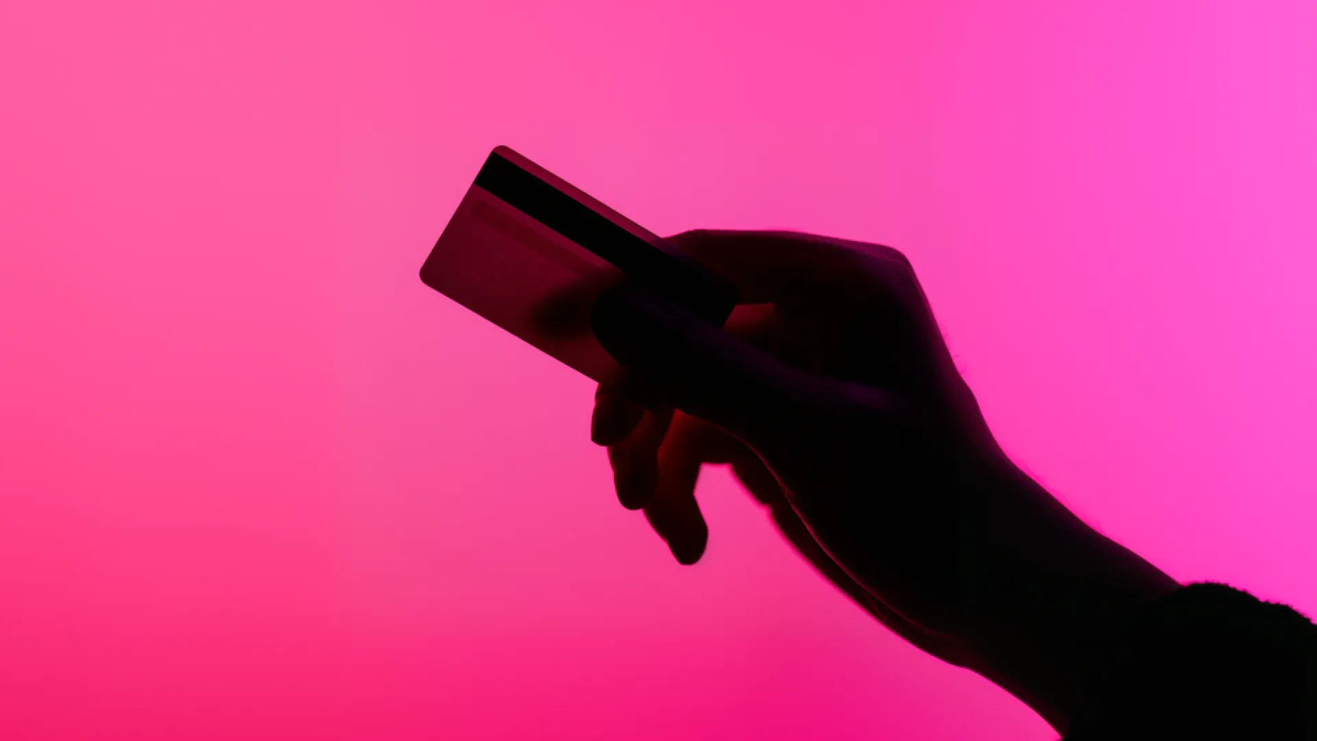 une main qui tient une carte sur fond rose