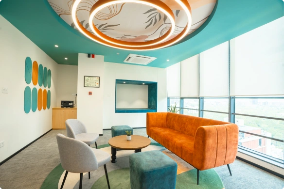 Modern Ignosis AI office with a wooden table, teal chairs, ceiling plants, and a bright, open workspace.